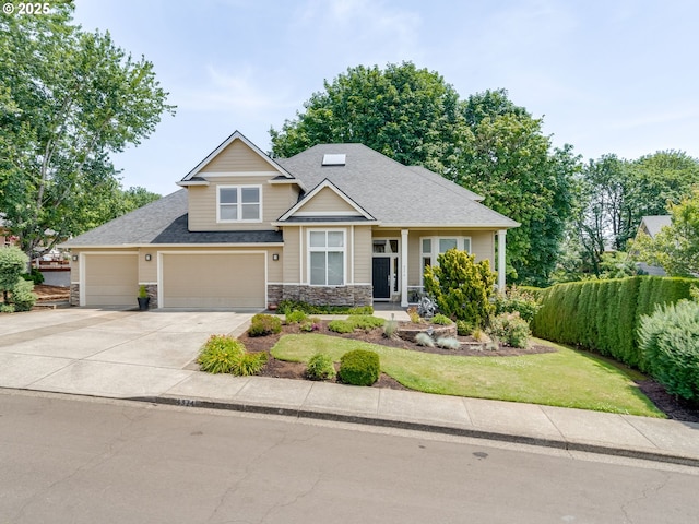 4374 M Loop, Washougal, WA 98671 - craftsman house featuring concrete driveway, stone siding, roof with shingles, a front yard, and a garage