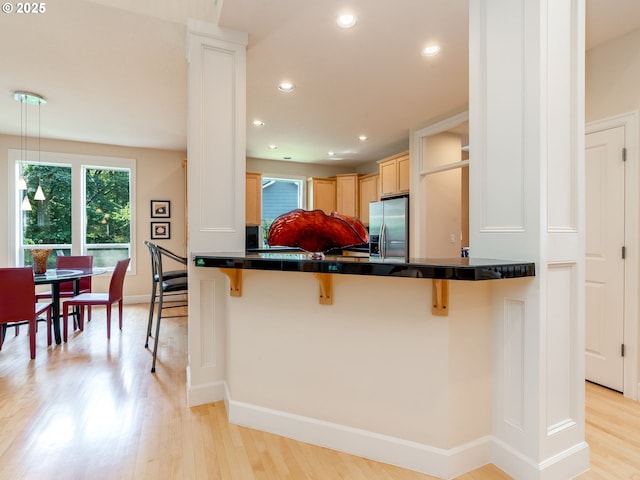 4374 M Loop, Washougal, WA 98671 - kitchen featuring stainless steel fridge with ice dispenser, a kitchen breakfast bar, dark countertops, light wood-style flooring, and recessed lighting