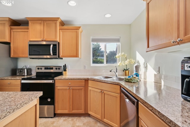 kitchen featuring light brown cabinetry, stainless steel appliances, and sink