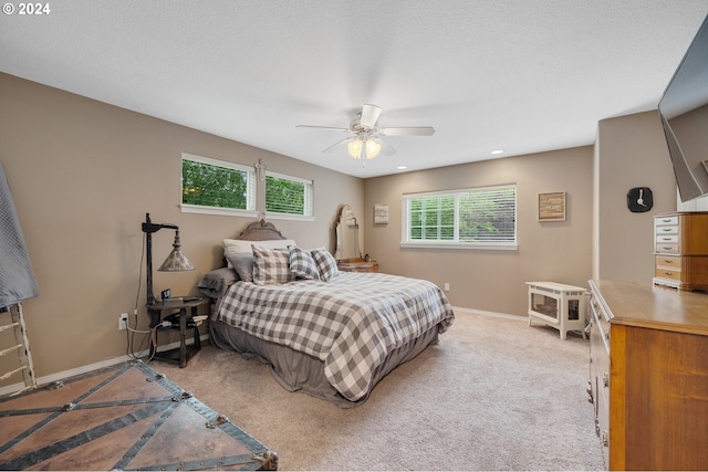 bedroom featuring multiple windows, a textured ceiling, and ceiling fan