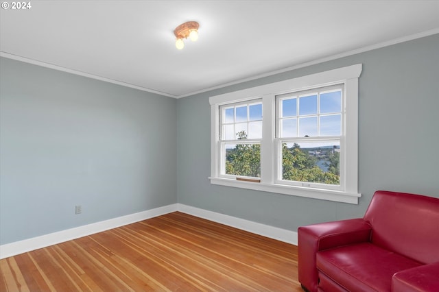 living area with ornamental molding and hardwood / wood-style flooring