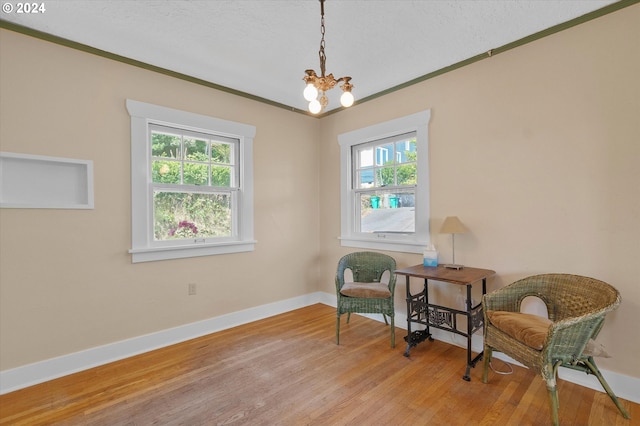 sitting room with an inviting chandelier, light hardwood / wood-style flooring, and a wealth of natural light