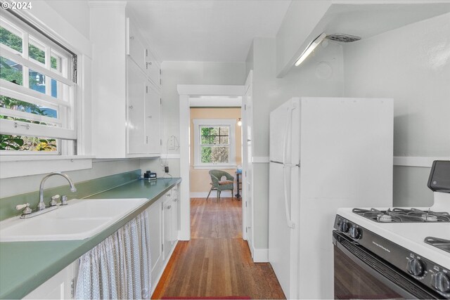 kitchen with wood-type flooring, white cabinets, and white gas range