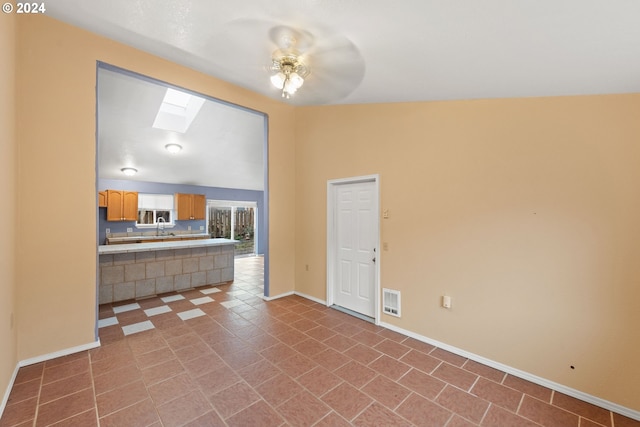 living room with high vaulted ceiling, sink, a skylight, tile patterned flooring, and ceiling fan