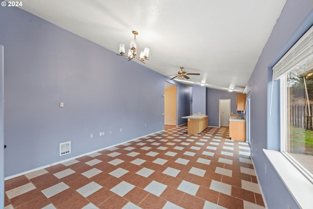 unfurnished living room featuring ceiling fan with notable chandelier