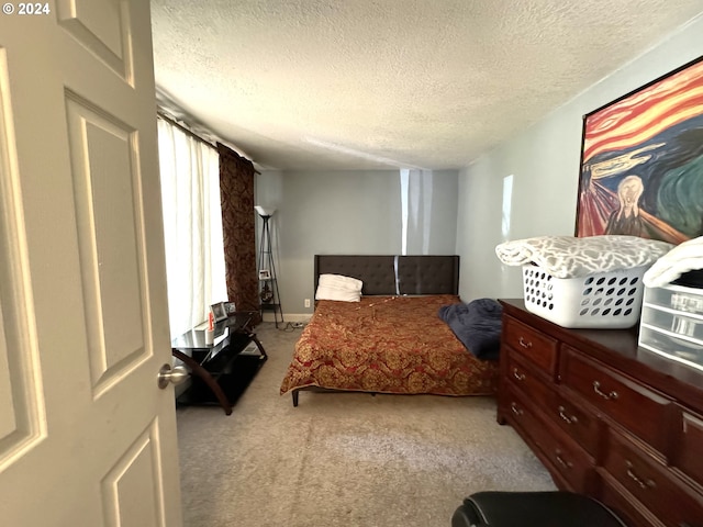 bedroom featuring light colored carpet and a textured ceiling