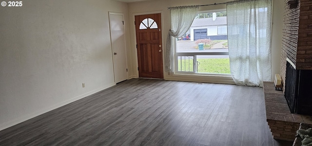 foyer with plenty of natural light, a fireplace, and wood finished floors