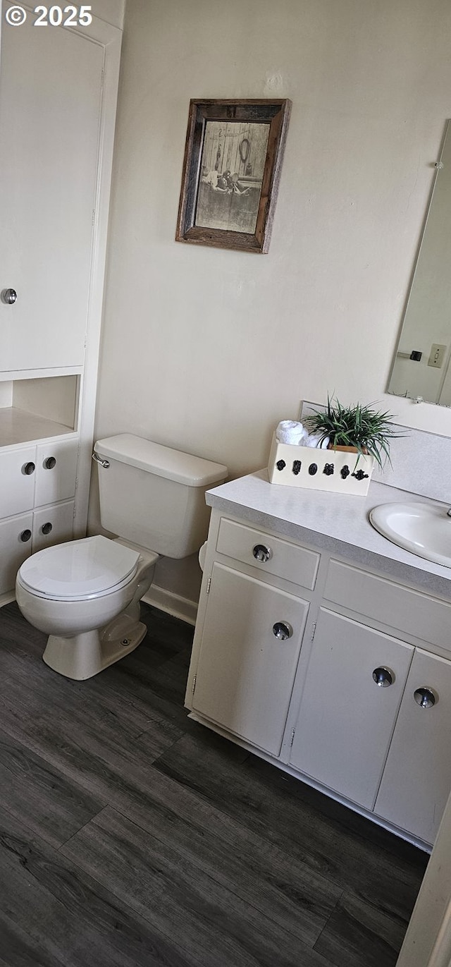 bathroom featuring toilet, wood finished floors, and vanity