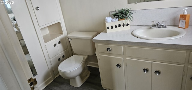 half bath featuring vanity, toilet, and wood finished floors