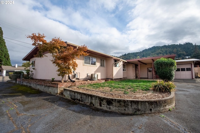 ranch-style home featuring a garage and fence