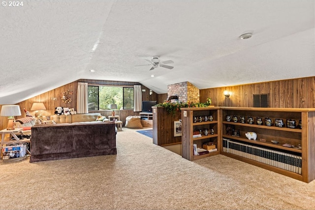 living room featuring wooden walls, ceiling fan, and a textured ceiling