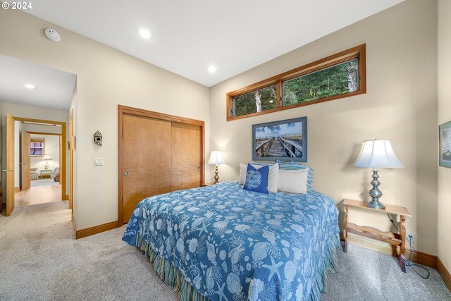 bedroom featuring light colored carpet and a closet