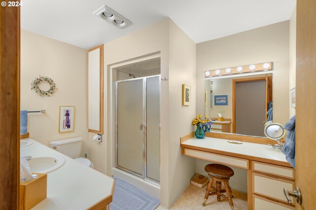 bathroom with vanity, a shower with shower door, and toilet