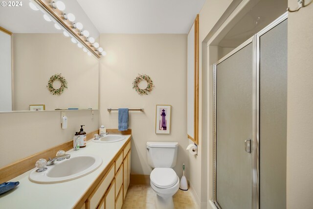 bathroom with a shower with door, vanity, and toilet