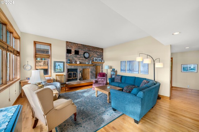 living room featuring a brick fireplace and light hardwood / wood-style floors