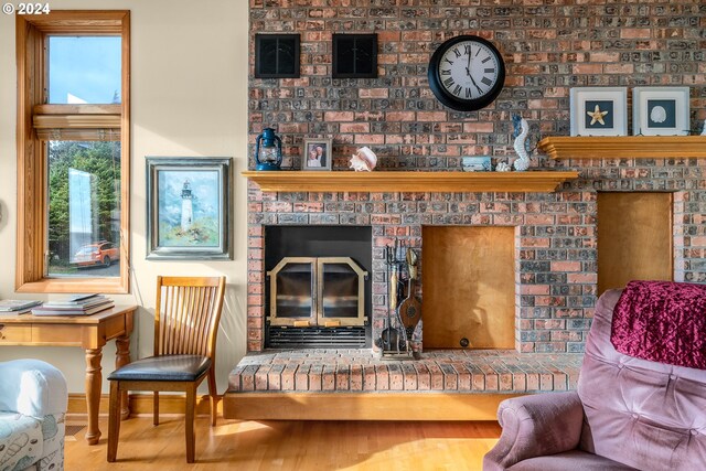 living room with hardwood / wood-style flooring and a brick fireplace