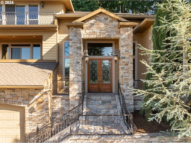 doorway to property featuring french doors, a balcony, and a garage