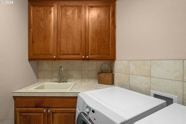 laundry room featuring cabinets, sink, and washer / dryer