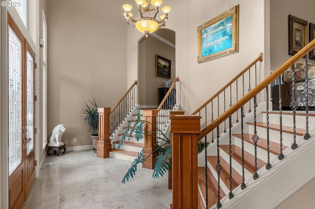 entrance foyer with french doors and a chandelier