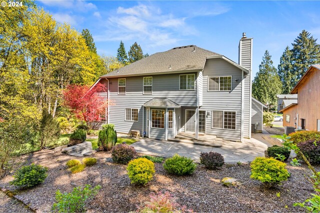 rear view of property featuring central AC unit and a patio area