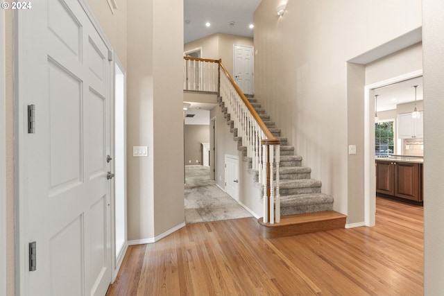 foyer entrance featuring light hardwood / wood-style flooring and a high ceiling