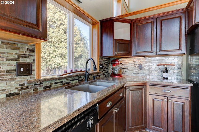 kitchen featuring backsplash, dishwasher, light stone countertops, and sink