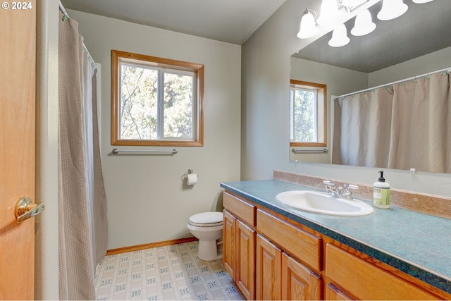 bathroom with plenty of natural light, toilet, and vanity