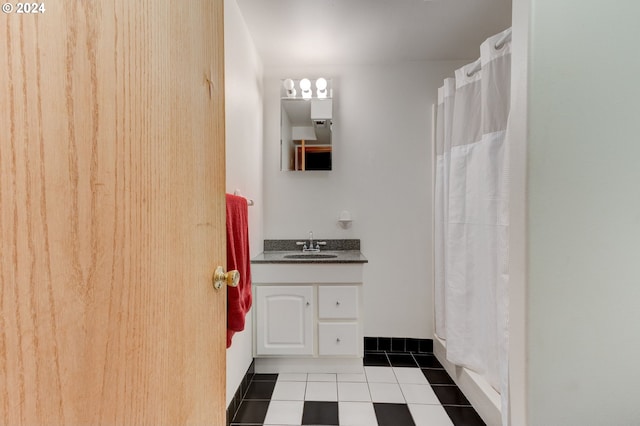 bathroom featuring tile patterned flooring, vanity, and walk in shower