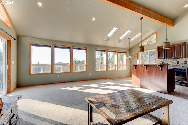 living room featuring beam ceiling, light colored carpet, high vaulted ceiling, and a skylight