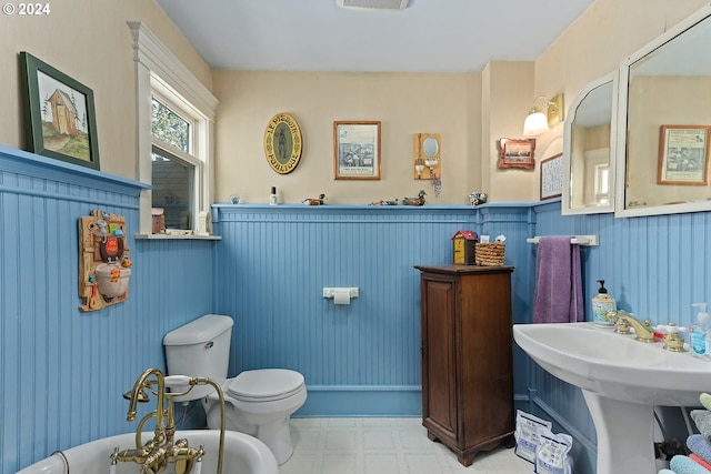 bathroom with visible vents, a wainscoted wall, a sink, tile patterned floors, and toilet