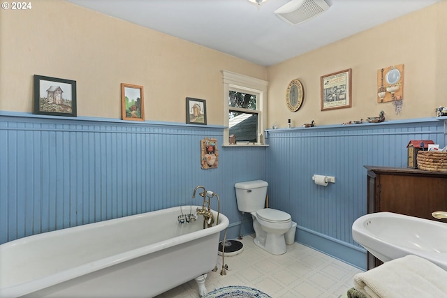 bathroom with toilet, a tub to relax in, and tile patterned flooring