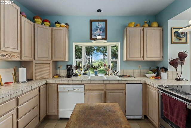 kitchen featuring electric range, sink, white dishwasher, and light tile patterned floors