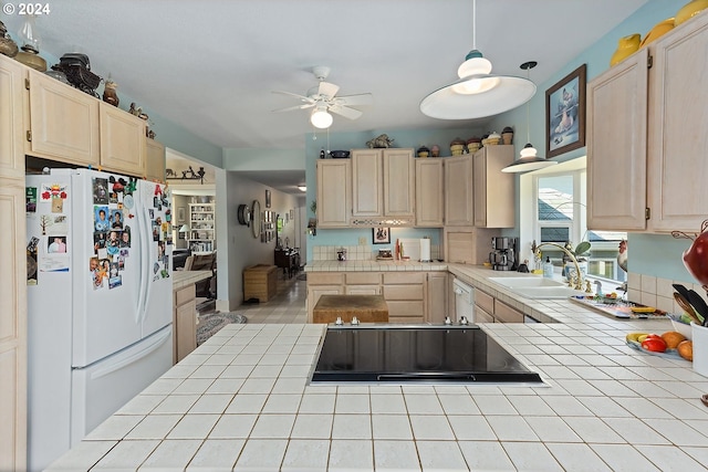 kitchen featuring light brown cabinetry, tile countertops, freestanding refrigerator, and a sink