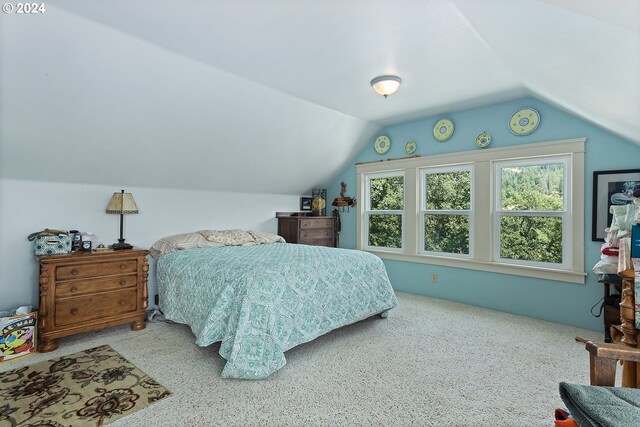 carpeted bedroom featuring lofted ceiling and multiple windows