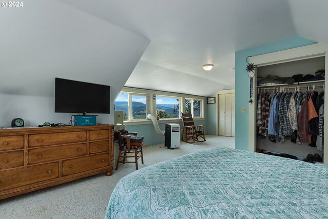 bedroom with lofted ceiling, a closet, and light colored carpet