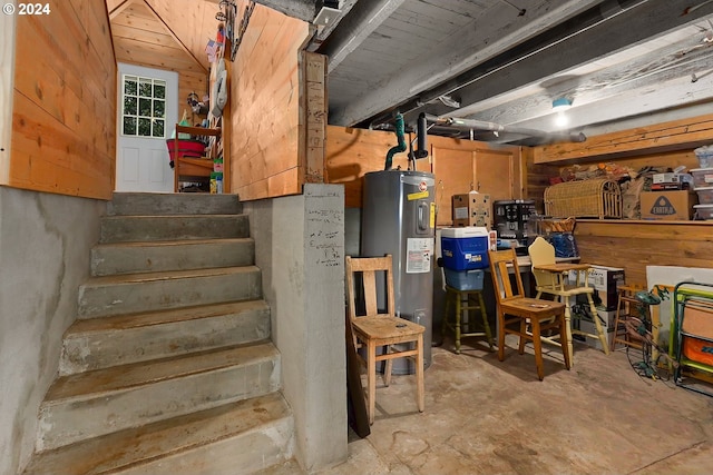 unfinished basement with stairway and electric water heater