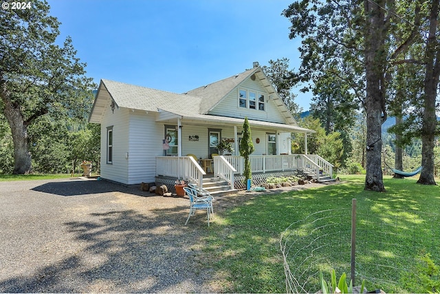 view of front of home featuring covered porch, driveway, and a front yard