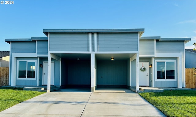 view of front of home with a front yard and a carport