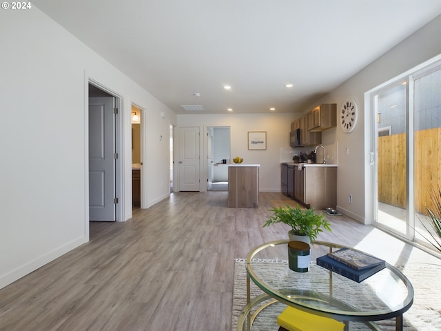 living room featuring sink and light hardwood / wood-style floors