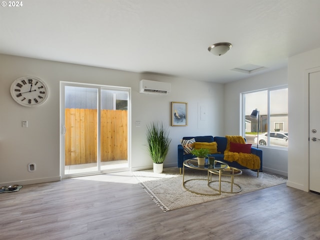 sitting room with light hardwood / wood-style flooring and a wall unit AC