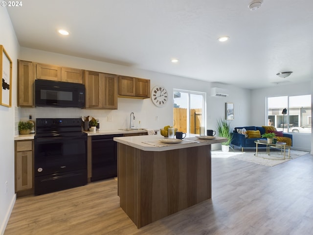 kitchen with a wall mounted AC, sink, black appliances, light hardwood / wood-style floors, and tasteful backsplash