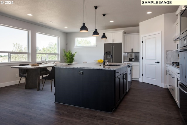 kitchen featuring dark hardwood / wood-style flooring, a kitchen island with sink, white cabinetry, hanging light fixtures, and built in fridge