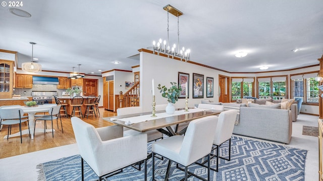 dining room featuring an inviting chandelier, crown molding, and light hardwood / wood-style flooring