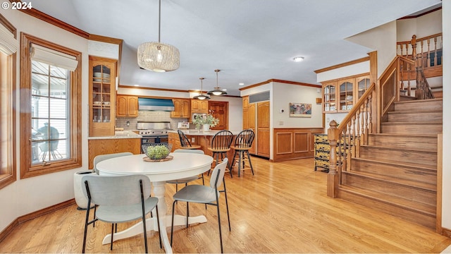 dining room with light hardwood / wood-style floors and crown molding