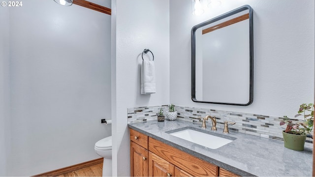 bathroom with vanity, decorative backsplash, and toilet