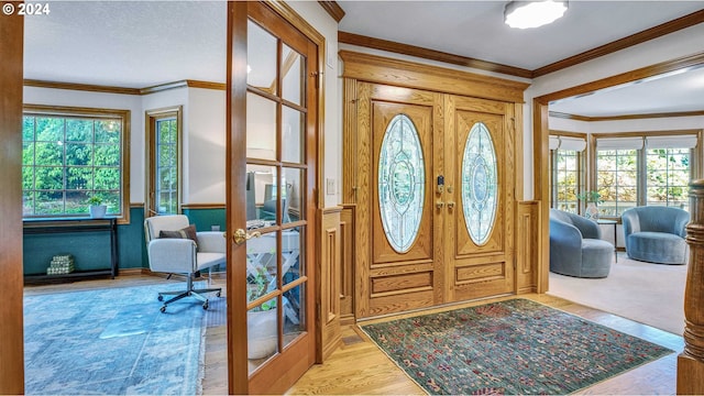 entryway featuring light hardwood / wood-style floors, french doors, and crown molding