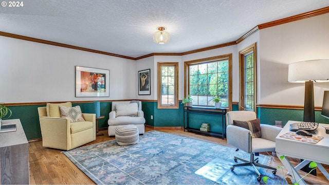 interior space with a textured ceiling, ornamental molding, and wood-type flooring