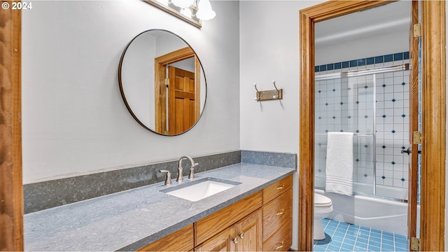 full bathroom with toilet, tile patterned flooring, enclosed tub / shower combo, and vanity