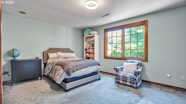 bedroom featuring a textured ceiling and carpet floors