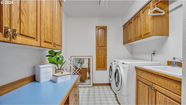 clothes washing area with cabinets, washer and clothes dryer, and sink